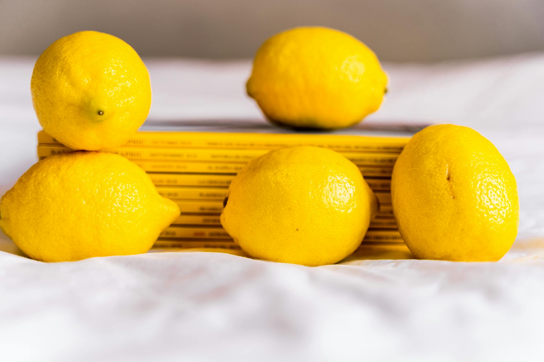 Woman holding a fresh lemon at a dining table, symbolizing freshness and new beginnings